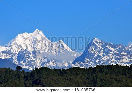 Snow Covered Beautiful Mountain Peaks Against The Blue Sky In Sikkim, India