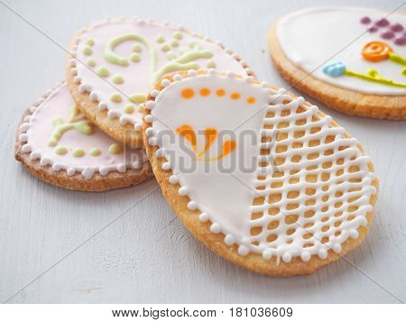 Pile of Easter sugar cookies glazed with royal icing. Ester treat upon rustic table. Beautiful biscuits in the shape of easter egg. Selective focus.