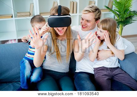 Happy family at home and playing with virtual reality goggles, VR headset, modern technology glasses