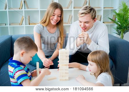 A happy family of four people playing jenga