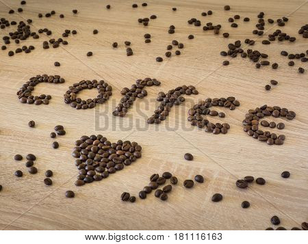 Coffee love message made with roasted beans over wooden background