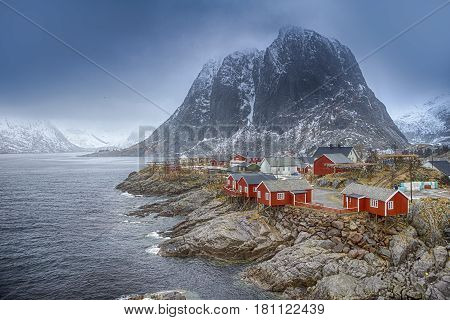 Travel Concepts and Ideas. Traditional Fishing Hut Village in Hamnoy Mountain Peak in Lofoten Islands Norway. Horizontal Image Composition