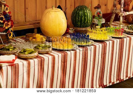 Pickled vegetables and cheese stand lie in serving dishes on a buffet