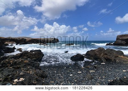 Gorgeous view of Aruba's black sand stone beach in Aruba.