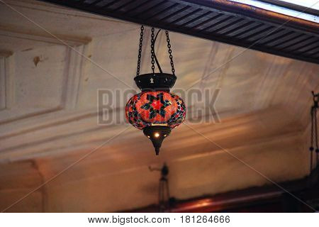 Red Turkish lantern hangs under the ceiling