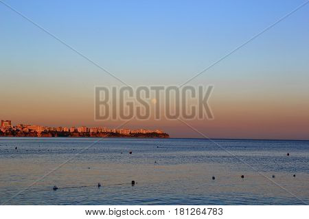 Sunset in the sea with the shoreline in sight