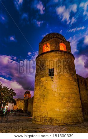 Night photo of Mosque in Sousse. Medieval architecture in night lights. Vivid picture of ancient religious building - one of the main attractions in Sousse, Tunisia.