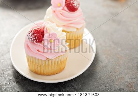 Pink vanilla and raspberry cupcakes with sugar flower