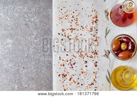 Grey abstract background with space for text. Olive oil jar vine vinegar jar bowl with olives on a white cloth with spices and sea salt. Healthy eating concept. Traditional food