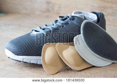 Gray running shoes with orthopedic insoles. Wooden board