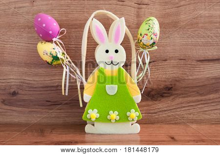toy rabbit with Easter eggs on wooden background