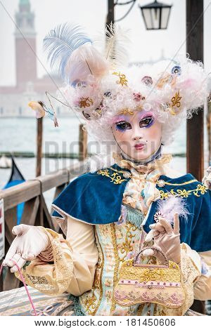 Blue and gold masked minx girl with carnaval costume, Venice, Italy.