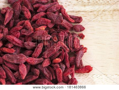 close up macro shot of goji berries on a pine table copy space to the right