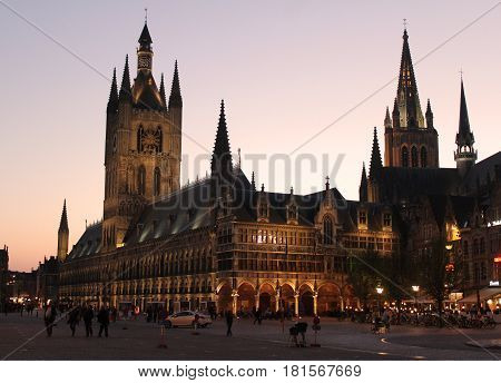 IEPER, BELGIUM, APRIL 8 2017: Sunset behind the beautiful landmarks of the Cloth Hall and St Martins church in Ieper. The town is a hugely popular tourist destination and a focus of war remembrance.