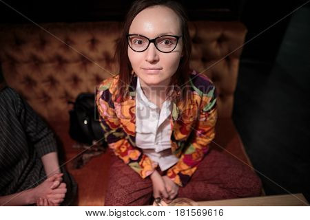 Young fashionable girl is sitting in cafe.