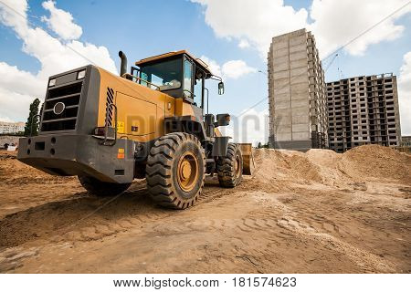 Yellow bulldozer working at the construction site