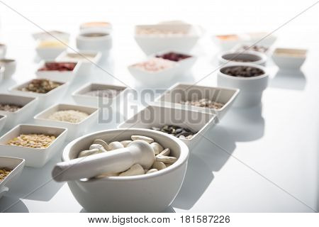 Spices and leguminous vegetables in bowls, isolated on white background