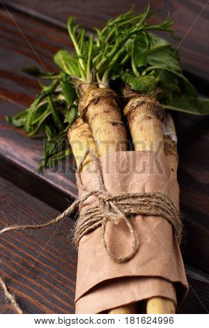 Raw Horseradish Roots On Wooden Background. Horseradish With Leaves.closeup. Selective Focus