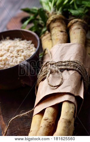 Raw Horseradish Roots On Wooden Background. Horseradish With Leaves.closeup. Selective Focus