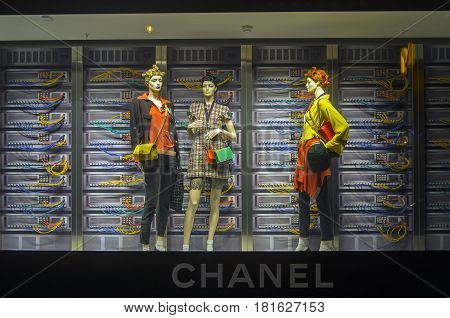 PARIS FRANCE - MARCH 27 2017: Installation in the showcase of the Printemps department store in Paris France. Fashion and high technology - elegant mannequins on the background of computer servers.