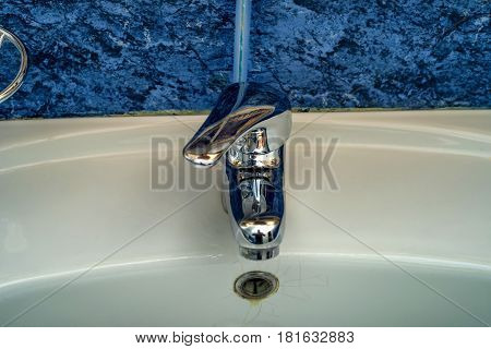 Close-up image of modern chrome tap and sink