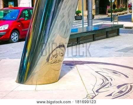Figueres, Spain - May 07, 2007: The unclear image on the ground is reflected on to the cylindrical pillar to form the image of the Salvador Dali with his famous moustache at Figueres, Spain on May 07, 2007
