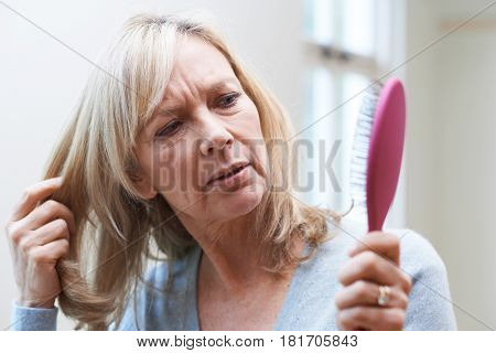 Mature Woman With Brush Corncerned About Hair Loss