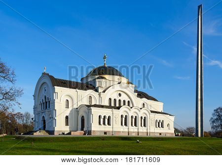 BREST BELARUS - DECEMBER 6 2015: Memorial complex "Brest Fortress-Hero". St. Nicholas Garrison Temple (1876) and bayonet-obelisk. Unknown people go to temple