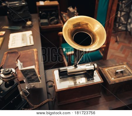 Ancient vintage gramophone in the interior of the office of a businessman of the early twentieth century, selective focus with blurred background