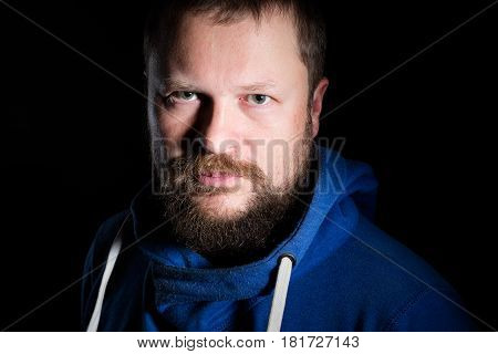 Solid bearded middle-aged man portrait on black background