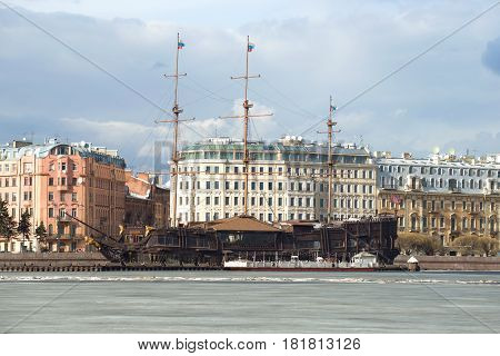 SAINT PETERSBURG, RUSSIA - MARCH 20, 2017: Floating restaurant in the form of an old sailing ship on the background of the Mytninskaya embankment on March day