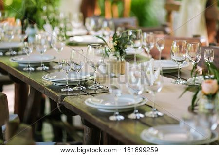 Glasses on the festive table setting. Wedding table decor concept. Table setting in classic style, setout. fine art.