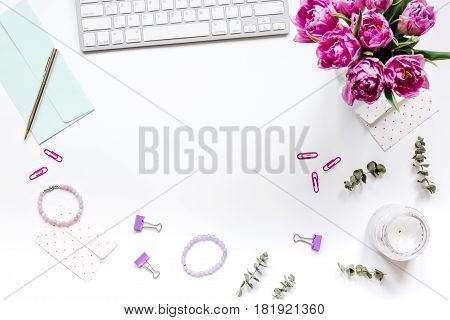 Work desk with spring flowers in home office concept on white background top view space for text