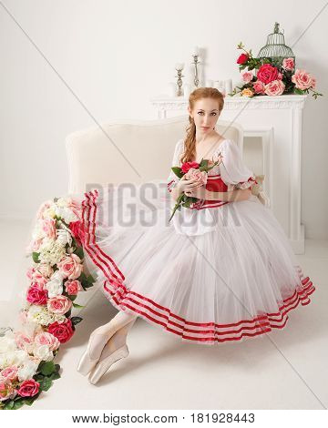Pretty ballerina in stage costume holding a bouquet of spring flowers. Retro dress.