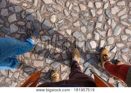 Three Friends Walk In Shoes Along The Pavement. Walk In The Fresh Air