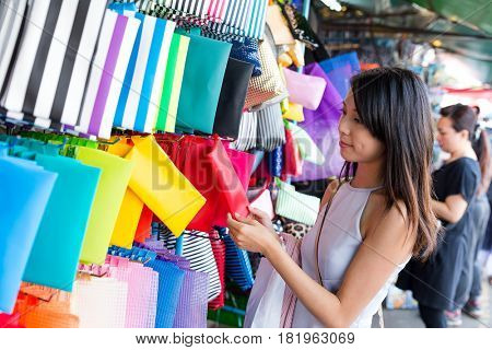 Woman choosing clutch in street market