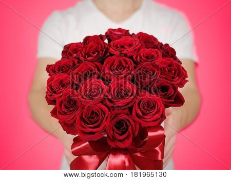 Man In White T Shirt Holding In Hand Rich Gift Bouquet Of 21 Red Roses. Composition Of Flowers In A