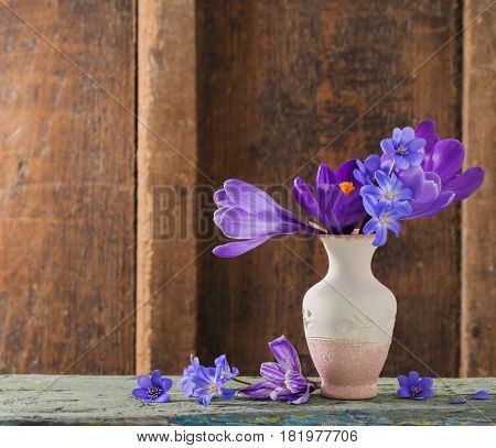 spring flowers in vase on wooden background