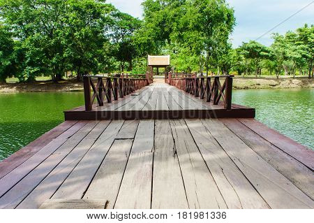 Line of wooden boardwalks live at Ayutthaya Thailand. This are green lagoon and forest be background.