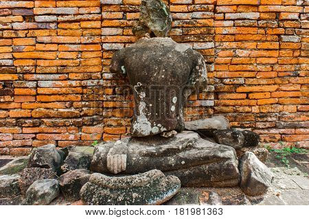Ancient Buddha statue are red brick wall in Ayutthaya Thailand.