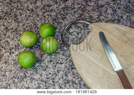 Lemon and cutting board wood with sharp knife to cut on granite stone background. It best for equipment food and kitchen.