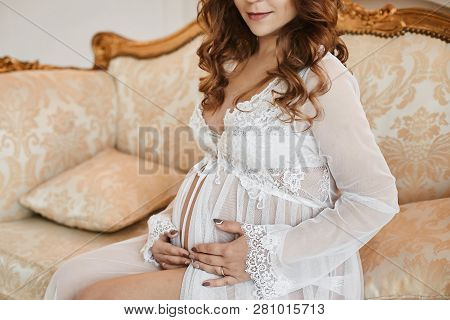 Beautiful Brown-haired Young Pregnant Woman With Fashionable Hairstyle And Manicure In A Stylish Pei
