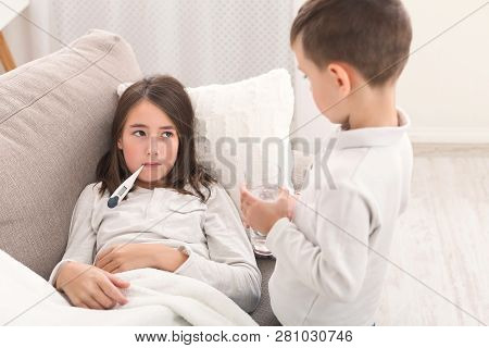 Brother Brought Water For Sick Sister, Measuring Temperature, Lying On Sofa At Home
