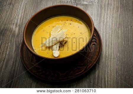 Yellow Cream Soup Decorated With Mushrooms And Two Slices Of Dried Bread
