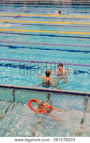 Poznan, Poland - January 26, 2019: Children And A Adult During Swimming Lessons In A Pool In The Ter