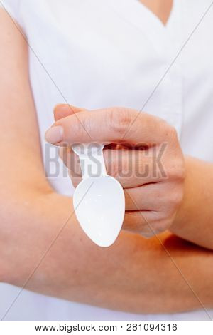 A Young Woman Doctor Distributes Portions Of Drugs In The Hospital, Determining Each Put Milliliters
