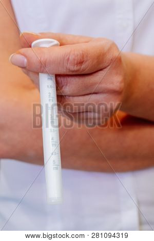 A Young Woman Doctor Distributes Portions Of Drugs In The Hospital, Determining Each Put Milliliters