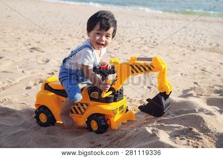 Asian Boy Play A Toy Of Excavator With A Sand On The Beach, This Immage Can Use For Kid, Toy, Play A