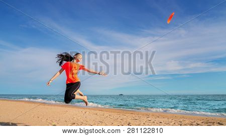 Asian Girl Play Flying Disc  On The Beach, This Immage Can Use For Sport, Play, Summer, Sea, Travel 