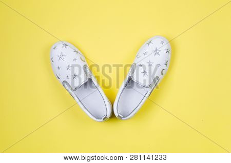 Women Or Teenage Fashion, White Slipons, Stylish Shoes On Yellow Background. Beauty And Fashion Conc